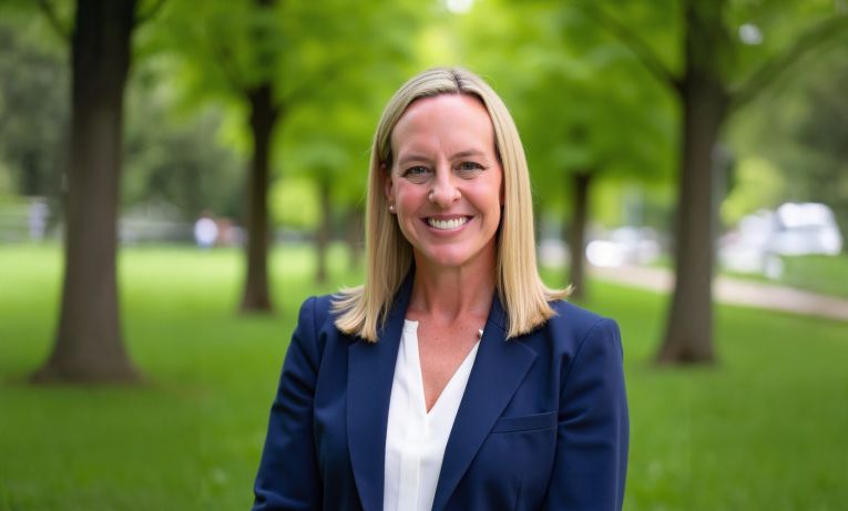An image of Alanna Morrison in front of a greenery background with several trees