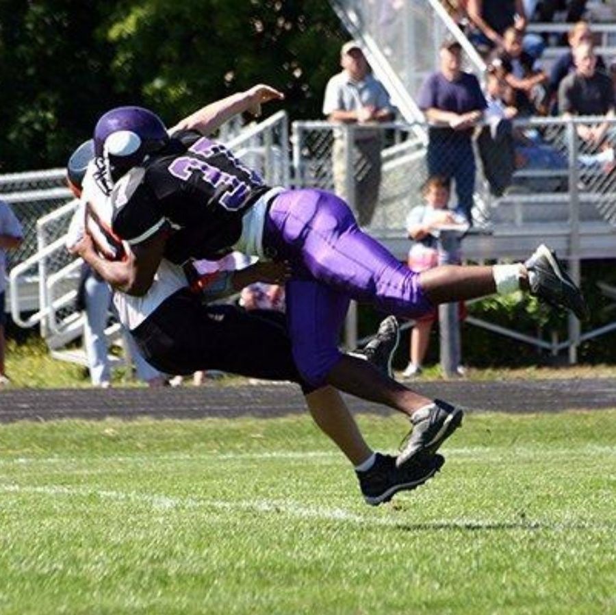 One football player tackles another. (Photo by Getty Images.)