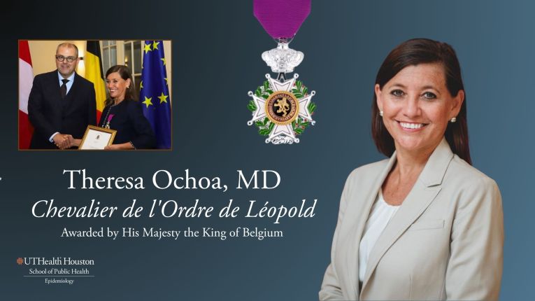 Woman shaking hands with a man next to a large white medal with a smiling woman
