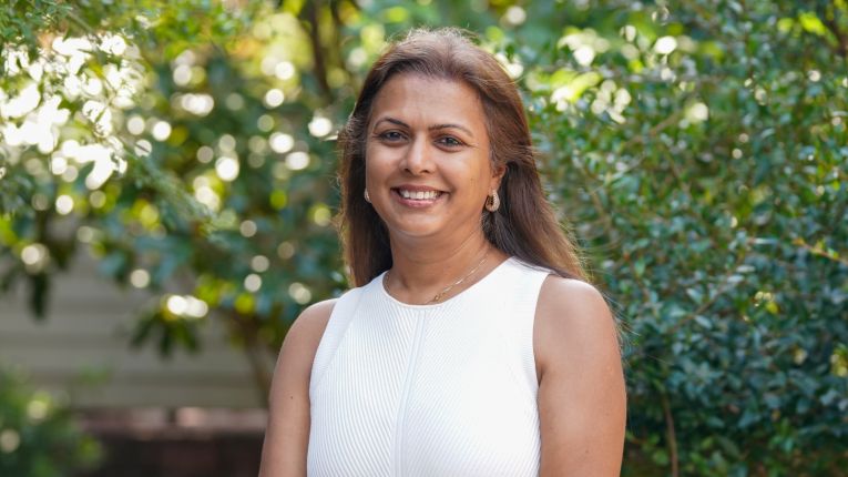 Shreela Sharma pictured in front of greenery.