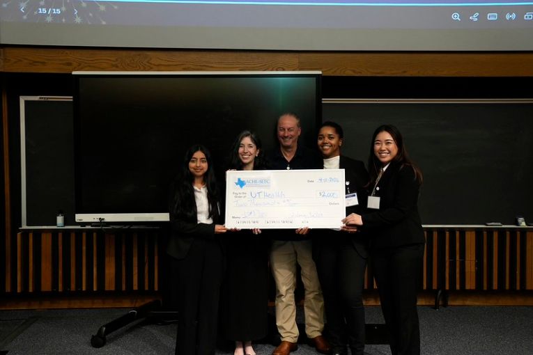 5 people smiling at the camera holding winning check from the fleming center case competition