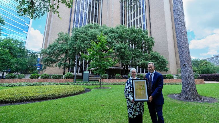 Lorann, PhD, and Jared Stallones, PhD, hold a commemorative plaque of the first blue print of the School of Public Health building. (Photo by UTHealth Houston))