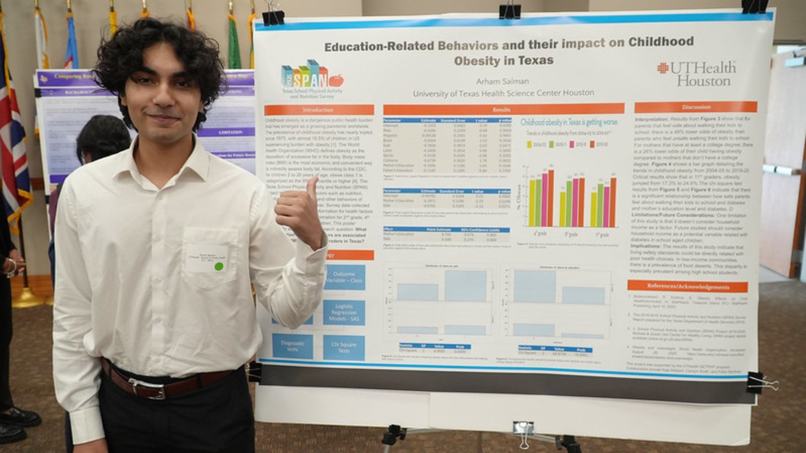 Arham Salman pictured in front of research poster.