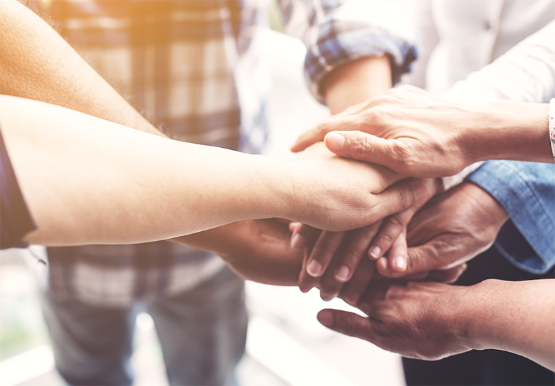group of poeple focusing on the arms holding hands